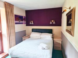 um quarto com uma cama com duas toalhas em The Coach House at Missenden Abbey em Great Missenden