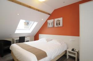 ein Schlafzimmer mit einer orangefarbenen Wand und einem Bett in der Unterkunft Hotel Sabot D'Or in Blankenberge