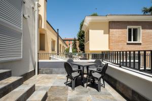 Un patio con una mesa y sillas en un balcón. en Giorgi Design Homes I, en Bolonia