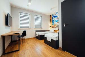 カリシュにあるblue hotelのベッド2台、デスク、ドアが備わる客室です。