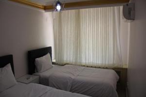a hotel room with two beds and a window at Abbasi Apart (H) in Çekirge