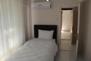 a bedroom with a white bed with a white pillow at Abbasi Apart (H) in Çekirge