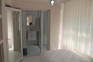 a bedroom with a bed and a bathroom with a shower at Abbasi Apart (H) in Çekirge