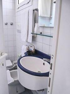 La salle de bains blanche est pourvue d'un lavabo et de toilettes. dans l'établissement Hotel Acerboli, à Rimini