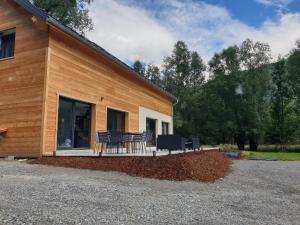 a building with a porch with chairs on it at Charmante Maison La Source in Grandes Sables