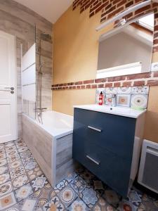 een badkamer met een bad, een wastafel en een bad bij les Gîtes du Château de Maltot in Saint-Ouen-du-Breuil