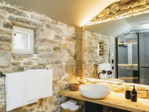 a bathroom with a sink and a stone wall at Locanda San Silvestro - Meride in Mendrisio