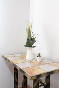 a table with a vase of flowers on it at Casa Gabriela Hotel in Jiménez de Jamuz