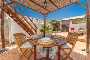 Una mesa y sillas de madera en un patio. en Beach Apartment, en Playa de Santiago