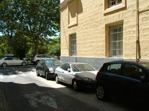 three cars parked on a street next to a building at Centro Histórico con parking Cádiz in Cádiz