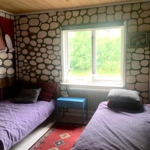 1 dormitorio con 2 camas y ventana en Arthome Småland, en Ruda