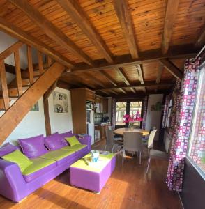 a living room with a purple couch and a table at Holiday village in Réclinghem