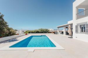 una piscina en el patio trasero de una villa en Villa Bini Maria à Binibeca - 10 couchages - vue mer, en Sant Lluis