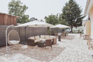 a patio with couches and tables and umbrellas at Casa Merilana in Rust