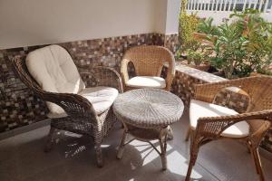 a group of wicker chairs and a table in a room at Casa Gales: Relax next to the Sea Apartment for Families in Corralejo