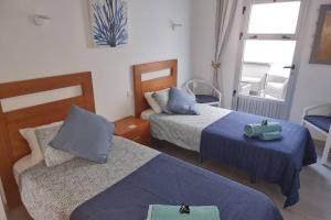 a hotel room with two beds and a window at Casa Gales: Relax next to the Sea Apartment for Families in Corralejo