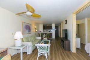 a living room with a couch and a ceiling fan at Spacious One Bedroom Harbor View Condos at Ilikai Marina With Private Balcony in Honolulu