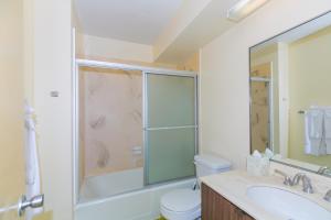 a bathroom with a shower and a toilet and a sink at Spacious One Bedroom Harbor View Condos at Ilikai Marina With Private Balcony in Honolulu +16 photos