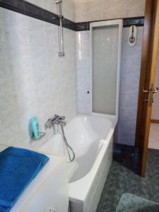 baño con bañera blanca y toalla azul en "La Gardenia" Affittacamere, en Marina di Montemarciano