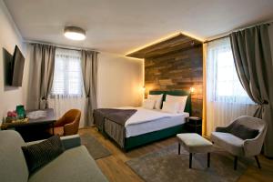 Habitación de hotel con cama y sofá en B&B Plitvice Holiday Lodge, en Lagos de Plitvice