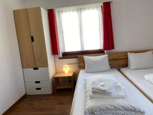a small room with two beds and a window at Berggasthaus Piz Calmot in Andermatt