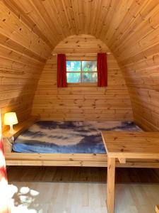 łóżko w drewnianym domku z oknem w obiekcie Camping Dolce Sole w mieście Marina di Massa