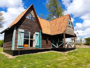 an old house with a brown roof on a field at Holiday village in Réclinghem