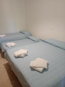 マリーナ・ディ・マッサにあるHotel Capriceの白い枕が付いたベッド3台