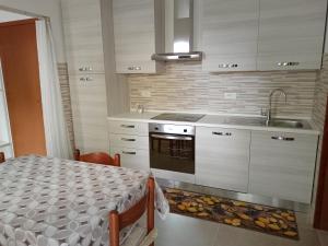 a kitchen with a table and a sink and a stove at Hotel Caprice in Marina di Massa