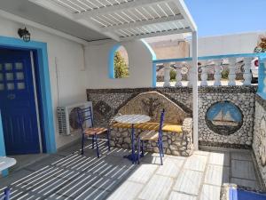 a patio with a table and chairs on a wall at Stavros Beach Villas in Perivolos