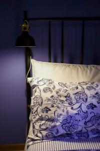 a bed with a blue and white pillow and a lamp at La casa del barbiere in Loreto +9 photos