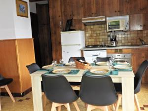 kuchnia ze stołem z 4 krzesłami oraz kuchnia z kuchenką w obiekcie Manoir 1 appt Les Gets w mieście Les Gets