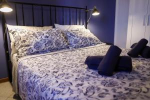 a bed with blue and white sheets and pillows at La casa del barbiere in Loreto