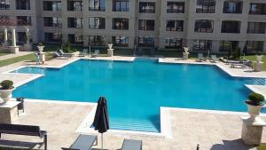 a large blue swimming pool in front of a building at Les Faberges in Carpe Vita in Varna City