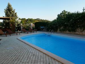 una grande piscina blu con panchine intorno di B&B Villa Floriana a Tortoreto