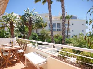 a balcony with a table and chairs and palm trees at Large Penthouse Near Porto de Mos Beach With Magnificent Views In Lagos in Lagos