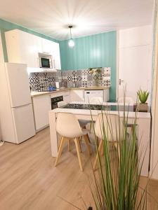 uma cozinha com armários brancos e uma mesa e cadeiras em LPA em Annecy
