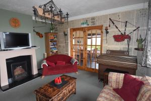 a living room with a fireplace and a piano at Slieve Elva B&B in Lisdoonvarna