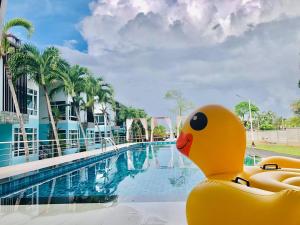 a yellow rubber duck sitting next to a swimming pool at จวรีน ลอร์ด รีสอร์ท แอนด์ โฮเทล - Javarine Lord Resort&Hotel in Chao Lao Beach