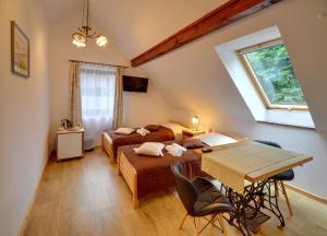 a bedroom with two beds and a table in it at Dom Krawca - pod Chojnikiem in Jelenia Góra