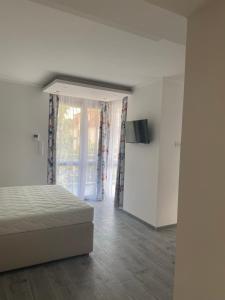 a white bedroom with a bed and a window at Szőlőlugas Vendégház in Balatonfüred