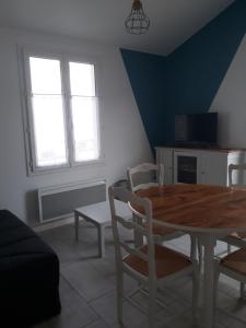- une salle à manger avec une table et des chaises en bois dans l'établissement Maisonette 200m de la plage, à Saint-Jean-de-Monts