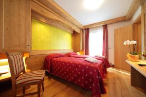 a bedroom with two beds and a window and a desk at Hotel Al Sole in Tarvisio