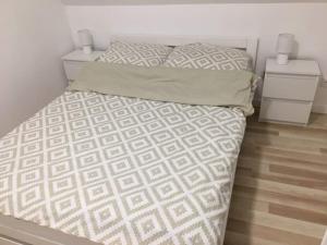 ein Schlafzimmer mit einem Bett mit einer weißen Bettdecke und Kissen in der Unterkunft Osada Zdrojowa u Martyny in Długopole Dolne