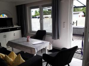 a living room with a table and chairs and a window at Serene Bungalow in Neubukow with Garden in Neubukow