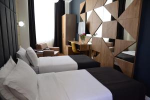 une chambre d'hôtel avec deux lits et un bureau dans l'établissement Hotel Comfort, à Tirana 44 autres photos