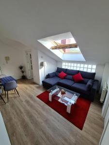 sala de estar con sofá azul y alfombra roja en Apartamento nuevo en El Astillero en El Astillero