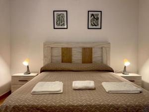 a bedroom with a large bed with two lamps at Apartamentos "EL BARCO" in La Guardia