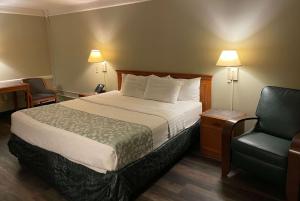 A bed or beds in a room at Travelodge by Wyndham Tuscaloosa