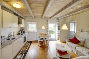 Il dispose d'une cuisine et d'un salon avec un canapé et une table. dans l'établissement fewo1846 - Rotes Haus - idyllisch gelegenes Haus mit 2 Schlafzimmern und großem Grundstück, à Husby